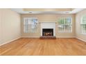 Inviting living room with hardwood floors and a brick fireplace, illuminated by natural light through large windows at 2881 Bridle Creek Sw Dr, Conyers, GA 30094