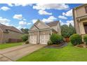 Angle view of a brick home featuring a two-car garage, a well-manicured lawn, and a driveway at 405 Highbranch Cir, Lawrenceville, GA 30044