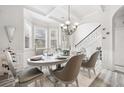 Elegant dining room with stylish chandelier, decorative ceiling, and adjacent staircase at 4608 Treasure Ct, Forest Park, GA 30297
