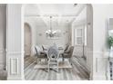 Inviting dining room with coffered ceiling, decorative chandelier, and modern gray flooring at 4608 Treasure Ct, Forest Park, GA 30297