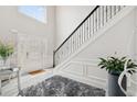 Elegant foyer with high ceilings, a decorative staircase with iron railings, and gray wood floors at 4608 Treasure Ct, Forest Park, GA 30297