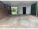 Spacious carport featuring a large concrete pad, enclosed storage, and an opening to the backyard at 4889 Fairforest Dr, Stone Mountain, GA 30088