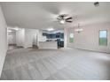 A bright, carpeted open floor plan featuring a kitchen with blue cabinets and stainless appliances at 6100 Semaphore Rdg, Rex, GA 30273