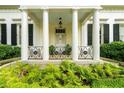 Up close image of front porch and ferns with columns and decorative ironwork at 2 W Muscogee Nw Ave, Atlanta, GA 30305