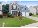 Attractive home with a manicured lawn, flowering shrubs, brick accents, and a two-car garage at 2530 Vistoria Dr, Cumming, GA 30041