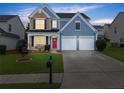 Charming two-story home featuring a red front door, two-car garage, and well-manicured lawn at 2530 Vistoria Dr, Cumming, GA 30041
