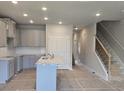 Spacious kitchen with gray cabinets, island sink and staircase at 2812 Lillian Ln, Douglasville, GA 30135