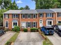 Attractive brick townhomes with black shutters and trimmed bushes, with ample parking on concrete driveway at 2779 Bentley Se Pl, Marietta, GA 30067