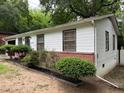 Side view of home featuring brick accents, white siding, and well-maintained landscaping at 2800 Browntown Nw Rd, Atlanta, GA 30318