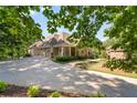 Spacious driveway leads to garages and charming home with landscaping at 7815 Bamby Rd, Cumming, GA 30041