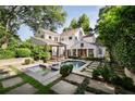 Gorgeous backyard featuring a sparkling pool, well-manicured lawn, and mature trees at 820 Highland Ne Ter, Atlanta, GA 30306