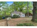 A single-story home features a yard with mature trees and a rustic, wooden walkway at 2505 Mellville Ave, Decatur, GA 30032