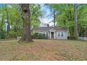 Single-story home nestled among large trees with a natural, leafy lawn at 2505 Mellville Ave, Decatur, GA 30032