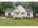 Charming home with a bright yellow door and manicured landscaping at 5745 Westwood Dr, Cumming, GA 30040