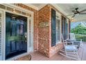 Welcoming front porch featuring a classic black door, brick accents, and comfortable rocking chairs at 403 Hidden Hills Ct, Canton, GA 30115
