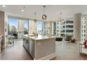 Open-concept living space with a kitchen island, floor-to-ceiling windows, and cityscape views at 1080 Peachtree Ne St # 1402, Atlanta, GA 30309
