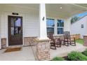 Inviting front porch with stone accents, rocking chairs, and a view of the manicured lawn, creating a warm welcome at 16 Dovecrest Way, Acworth, GA 30101
