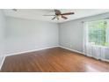 Spacious bedroom with hardwood floors, a ceiling fan, and a bright window at 2201 Colonial Oak Way, Stone Mountain, GA 30087