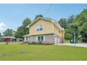 Two-story home featuring yellow siding, brickwork, and a neatly maintained lawn at 2201 Colonial Oak Way, Stone Mountain, GA 30087