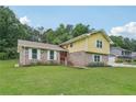 Two-story home with yellow siding and brick accent, set on a lush green lawn at 2201 Colonial Oak Way, Stone Mountain, GA 30087