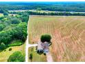 Expansive aerial view of the home surrounded by a large field and lush trees under a blue sky at 259 Hwy 11, Social Circle, GA 30025