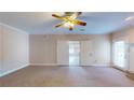 Bright living room with a ceiling fan and neutral carpet, opening into another room via double doors at 259 Hwy 11, Social Circle, GA 30025