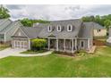 Charming home features a two-car garage and a well-manicured front lawn and an inviting front porch at 4721 W Lakeshore Dr, Acworth, GA 30101