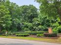 Entrance to the community featuring a black fence and attractive landscaping at 5580 Jamerson Dr, Atlanta, GA 30349