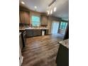 Kitchen with stainless appliances, wood floors, and sliding door access to the backyard at 5580 Jamerson Dr, Atlanta, GA 30349