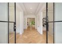Elegant entryway with herringbone wood floors and steel glass double doors to the house's interior at 4757 Lake Forrest Drive Northwest Dr, Atlanta, GA 30342