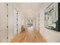 Hallway with beautiful artwork, neutral colors, and hardwood floors throughout the home at 4757 Lake Forrest Drive Northwest Dr, Atlanta, GA 30342
