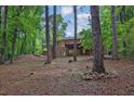 Backyard view of a brick home featuring a large deck and wooded area at 4774 Saint Bernard Sw Dr, Lilburn, GA 30047