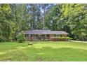 Charming brick ranch-style home featuring a well-manicured lawn and mature trees at 4774 Saint Bernard Sw Dr, Lilburn, GA 30047