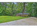 Brick ranch house with a well-maintained lawn and long driveway with mature trees at 4774 Saint Bernard Sw Dr, Lilburn, GA 30047