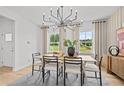 Bright dining room with modern chandelier, neutral walls, wooden table, and decorative artwork at 352 Foxglove Way, Mcdonough, GA 30253
