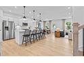 Open-concept kitchen with white cabinets, stainless steel appliances, and an island with bar seating at 352 Foxglove Way, Mcdonough, GA 30253