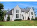 Two-story white brick home on a large lot with manicured lawn and mature trees at 530 Old Cobblestone Dr, Atlanta, GA 30350