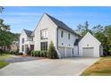 Two-story white brick home with a two-car garage and manicured lawn and driveway at 530 Old Cobblestone Dr, Atlanta, GA 30350