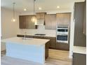 Modern kitchen features stainless steel appliances, stylish cabinets, a large island with quartz countertop at 62 Sheryl Way, Loganville, GA 30052