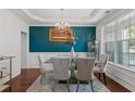 Elegant dining room featuring a glass table, upholstered chairs, and modern chandelier at 829 Castlebottom Dr, Lawrenceville, GA 30045