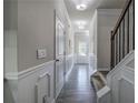 Inviting hallway with wood-look floors, decorative wainscoting, and modern lighting fixtures leading to the staircase at 158 Bryon Ln, Acworth, GA 30102
