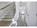 Hallway view featuring wood-look floors, staircase with iron railings, and an open transition to the living space at 158 Bryon Ln, Acworth, GA 30102