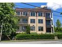 Multi-story building boasts neutral tones, balconies, large windows, and manicured landscaping at 281 15Th Ne St # 202, Atlanta, GA 30309