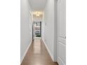 Bright hallway featuring hardwood floors, white walls, and contemporary lighting fixture at 147 Townview Dr, Woodstock, GA 30189