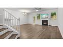 Open living room featuring wood floors, fireplace, and large windows that provide natural light at 147 Townview Dr, Woodstock, GA 30189