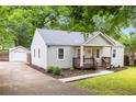 Side view of a quaint home, featuring a detached garage and a well-maintained yard with tasteful landscaping at 1927 Alexander Se St, Smyrna, GA 30080