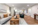 Sunlit living room with contemporary furnishings, a unique coffee table, and seamless flow to the kitchen at 1927 Alexander Se St, Smyrna, GA 30080