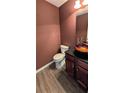 Stylish powder room featuring a vessel sink, modern faucet, and rich wall color at 4160 Post Oak Grv, Atlanta, GA 30349