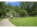 Beautifully manicured front yard with lush green lawn and winding driveway leading to the home at 7265 Hunters Branch Dr, Sandy Springs, GA 30328