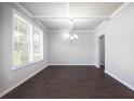 Bright dining room offers large windows, modern light fixture and hardwood floors at 113 Canal St, Hampton, GA 30228